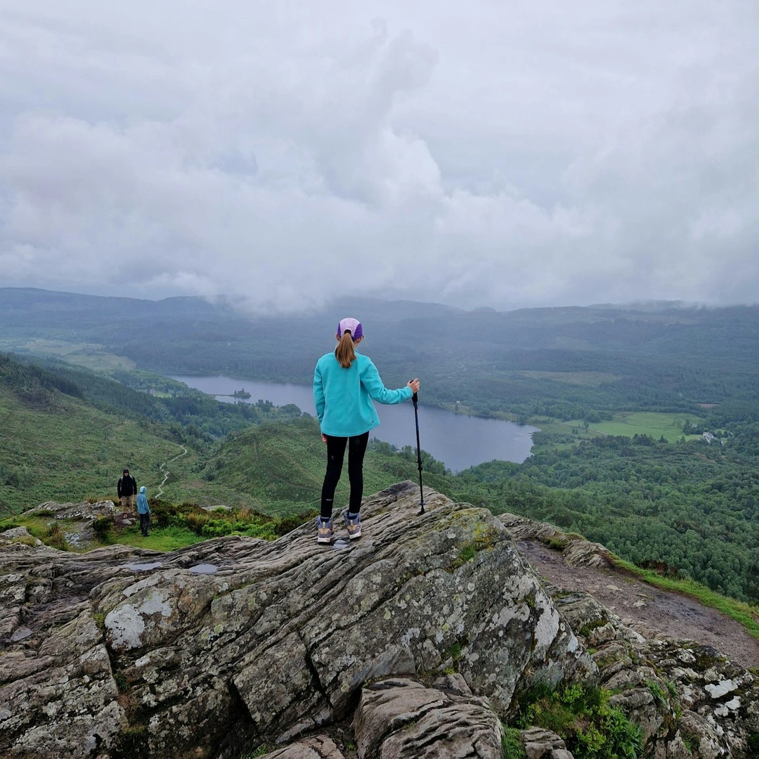 A girl soaks in the view from the summit of Ben A'an