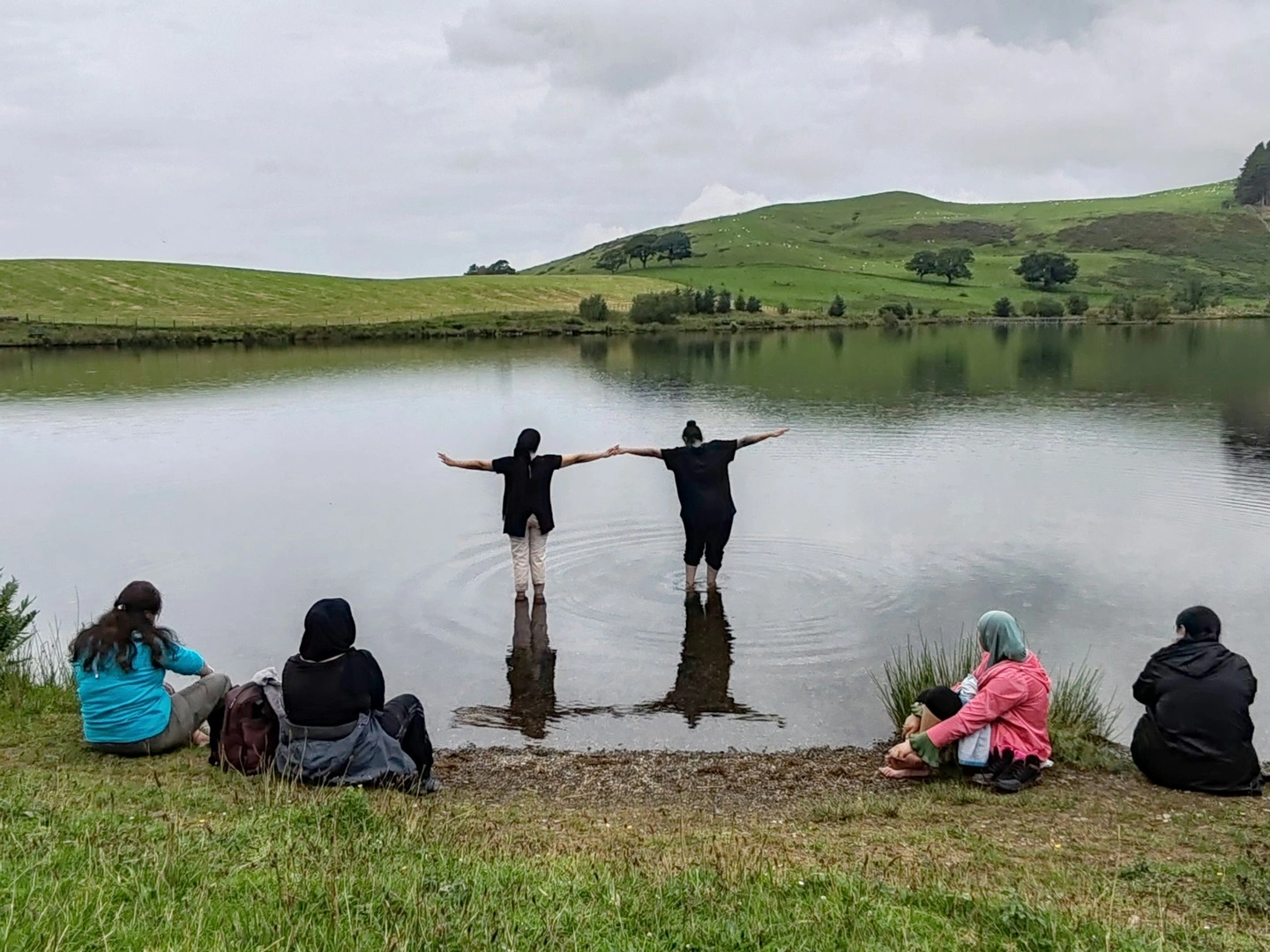 People resting by a lake and paddling.